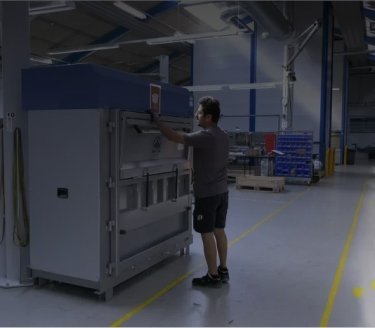 man in manufacturing environment operating a large Mil-tek baler